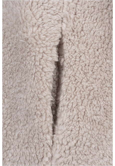 Närbild på det beigea, fluffiga sherpatyget på en UC Sherpa Jacket.